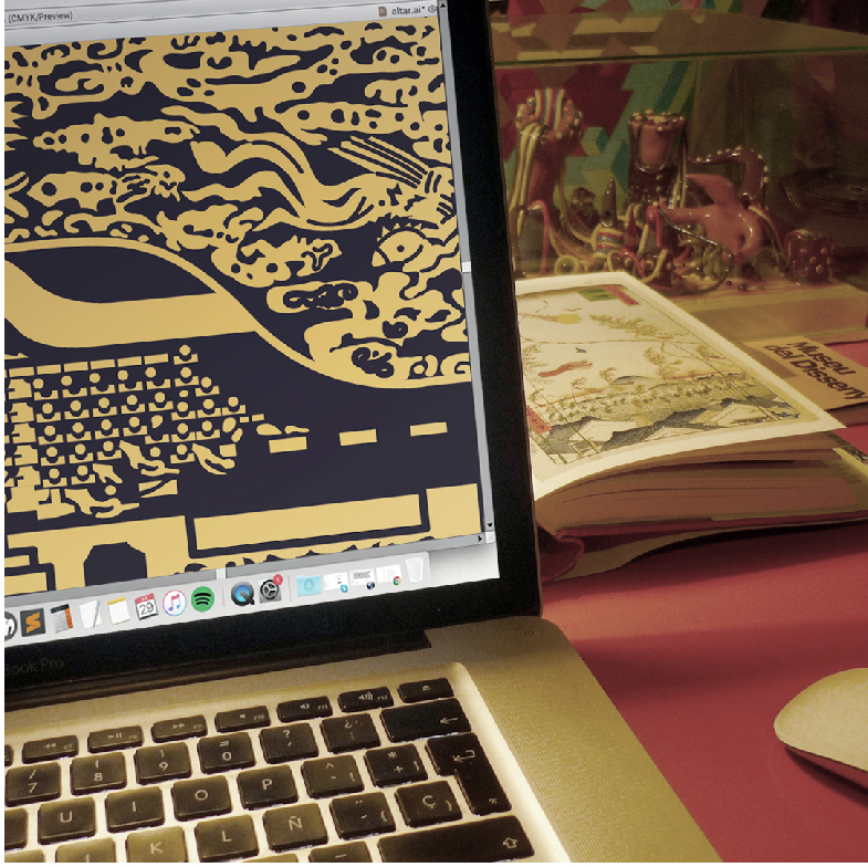 La imagen muestra una visión parcial de un escritorio de trabajo donde se puede ver una parte de una notebook que muestra en su pantalla un dibujo digital en proceso del altar budista japonés (aquí tiene algunos colores).